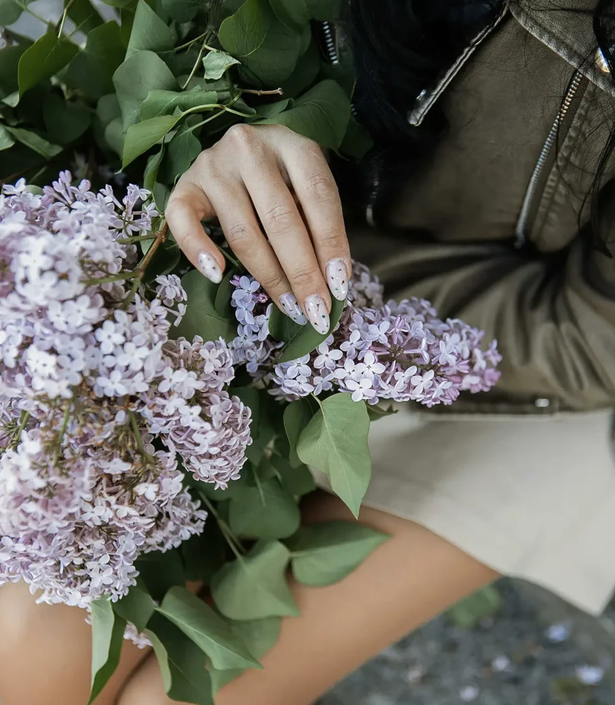 A woman gently holds a lilac bouquet, showcasing intricate details and natural beauty.