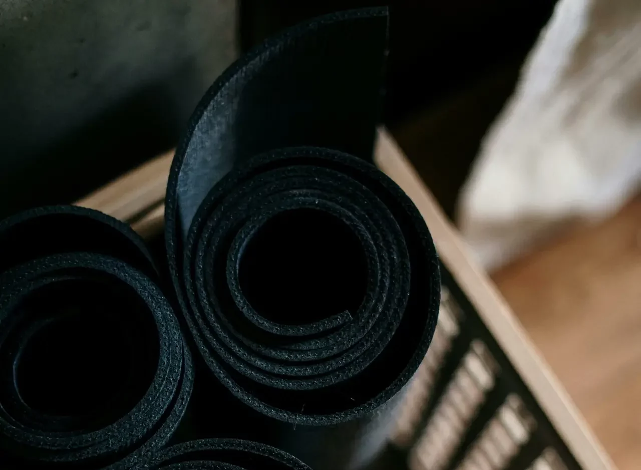 Close-up of rolled yoga mats in a basket at a fitness studio, ideal for yoga or pilates.